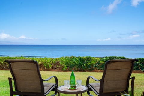Relax on the ground-floor patio where comfortable lounge chairs look out across a manicured lawn directly toward the blue waters of the Pacific.