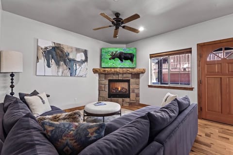 Relax into plush seating by the warmth of your stone fireplace, where rustic charm meets modern comfort in this inviting living space designed just for you.