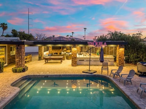 A twilight pool glow, string lights, and a covered patio lounge set the scene for unforgettable desert evenings.
