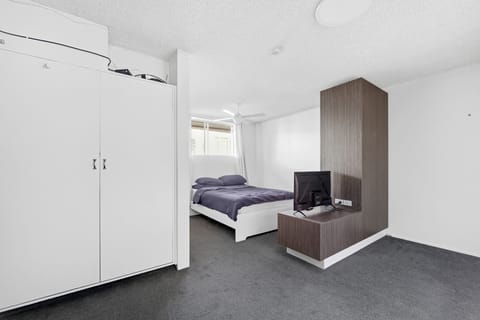 Bedroom with queen bed, wardrobe, and TV