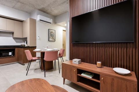 Sala con Smart TV, aire acondicionado, sofá cama individual y vista a la ciudad. Un espacio fresco y confortable para relajarte.