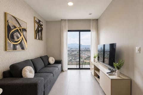 Sala con sofá cama, Smart TV y área climatizada, además de comedor para 4 personas y una agradable vista a la ciudad, ideal para relajarte y disfrutar de tu estancia.