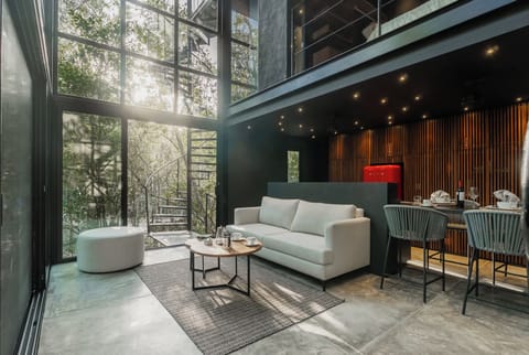Double-height living space surrounded by the Mayan jungle, where architecture and nature become one.