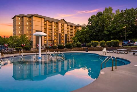 Resort-style outdoor pool with sunset views and relaxing lounge area