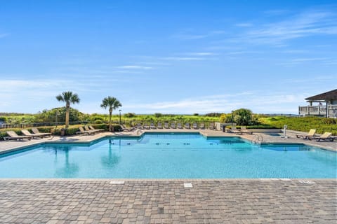 Resort-style ocean-view pool with ample loungers, steps from the beach.