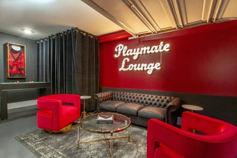 Luxurious leather couches, sleek modern coffee tables, and vibrant custom neon lighting.