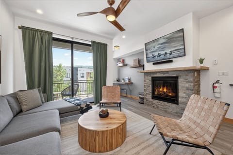 Sink into the plush sofa and let the glowing fireplace warm your evenings, while natural light floods through the balcony doors. Your perfect retreat awaits.