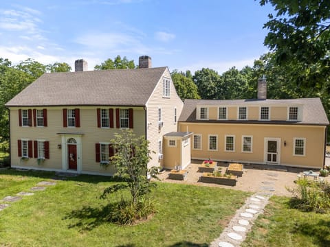 Elevated view of the yellow home and adjoining wing overlooking a courtyard.