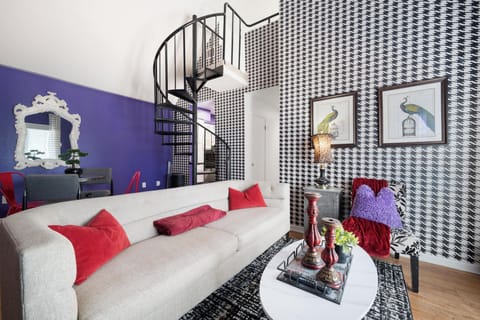 Chic living room with bold decor and a spiral staircase, perfect for relaxation and style.