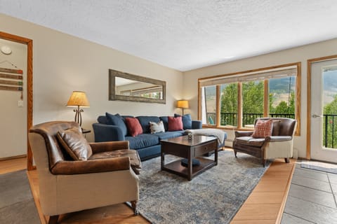 Picture yourself unwinding in this inviting living space, where plush seating and mountain views through expansive windows create your perfect retreat. The blend of rich leather and cozy fabrics invites you to settle in and truly relax.