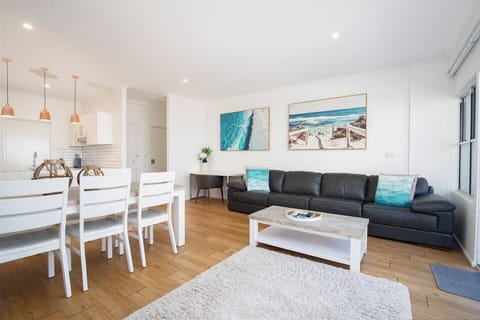 Relax and unwind in the sun-drenched living room, adorned with coastal inspired interiors and comfortable seating.
