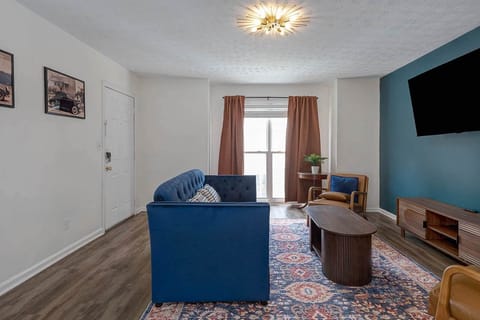 Retro living room with velvet sofa and vintage automobile art — your Columbus, GA home base minutes 