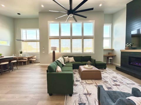 Drop your bags and claim a corner of the sectional — fire on, game up on the big screen, sunlight pouring down two stories of windows while the group trickles in.