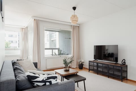 Bright living room with a comfortable sofa, TV unit and large window with natural light