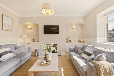 Grey lounge with half-height panelling and wall-mounted Smart TV.