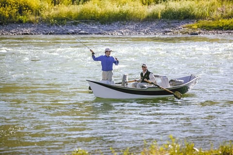 Wading into blue-ribbon fly fishing water on the Snake River, guided trips bookable through the sports shop