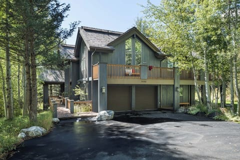 Timber siding and large windows front this two-level mountain home.