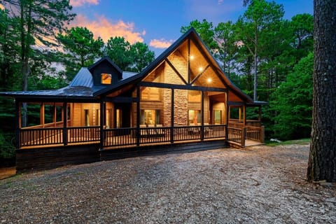 Twilight exterior of Boondock Ridge framed by tall pines and warm cabin lighting.