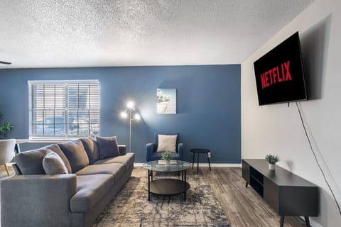Spacious and inviting living area with comfortable seating and a smart TV, perfect for relaxing after exploring Arlington or attending events at AT&T Stadium.