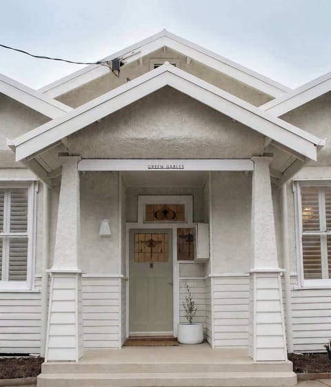 Welcome home to this charming white cottage, featuring a covered front porch, crisp gabled entryway, and inviting curb appeal.