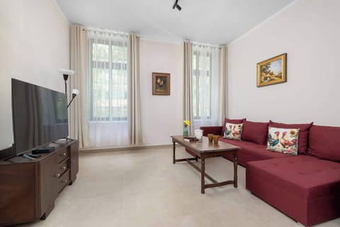 A stylish living room with a TV and a comfortable sofa. A great spot to unwind with your favorite movie.