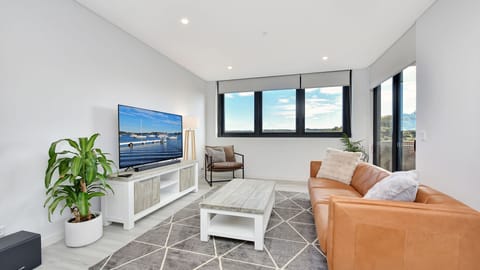 Bright open-plan living with smart TV and balcony access
