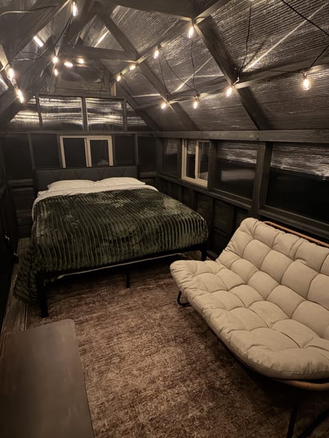 Cozy loft bedroom with warm string lights and a relaxing lounge sofa