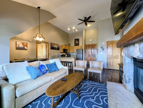 Inviting open-concept living space with vaulted ceilings and natural wood accents. Sink into the plush sofa, gather around the coffee table, and unwind in this warm mountain retreat.