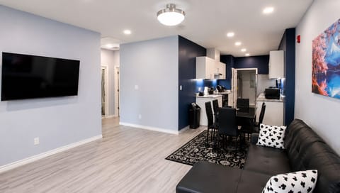 Living Room: Spacious with sofa bed, desk, 65” TV, blackout curtains.