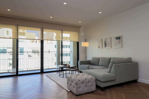 Bright living room with a cozy sofa and direct access to the private balcony.