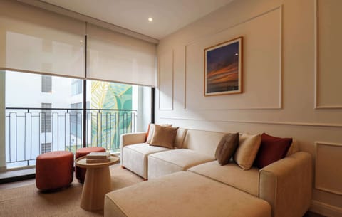 Bright and cozy living room with comfortable seating and natural light from the balcony.