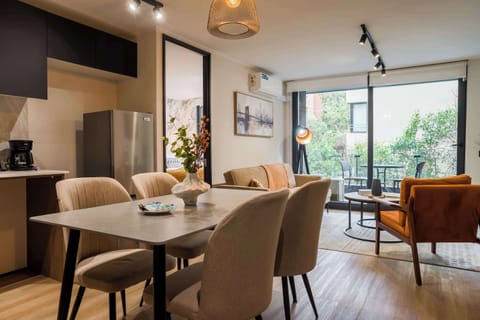 Spacious and stylish living area with modern decor and lush garden views, perfect for relaxing or entertaining.