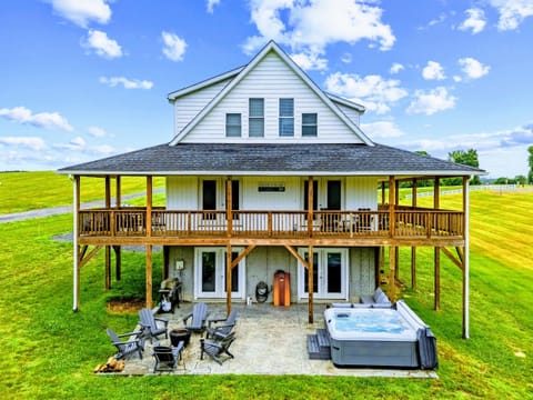 Aerial View - A closer look at the back of the house, wraparound porch above and hot tub, fire pit seating below.
