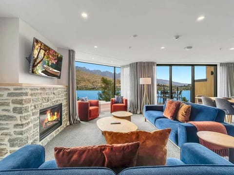 Spacious open-plan living with a cosy gas fireplace, designer furnishings, and breathtaking lake and mountain views.