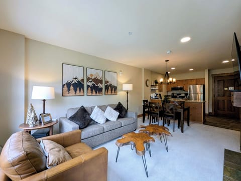 Sink into plush seating in your open-concept living space, where mountain-inspired artwork and warm lighting create a welcoming retreat after a day of adventure.