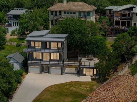 Welcome to your modern hillside retreat above Lake Travis, complete with tiered decks and a two-car garage.