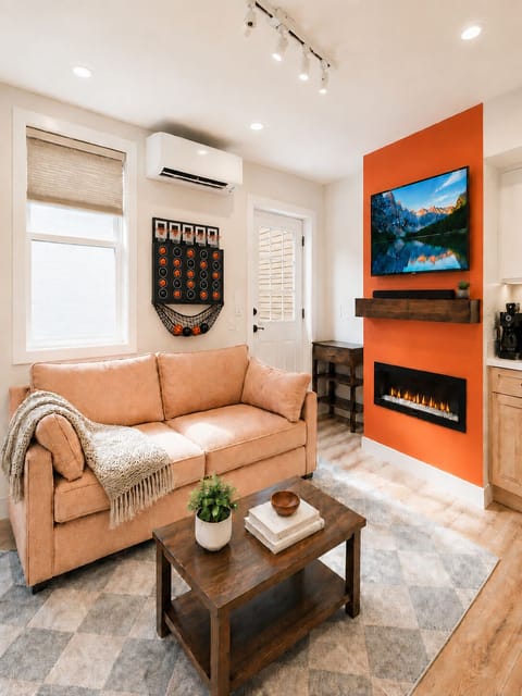 Cozy modern lounge with fireplace, TV, and bold designer accent wall
