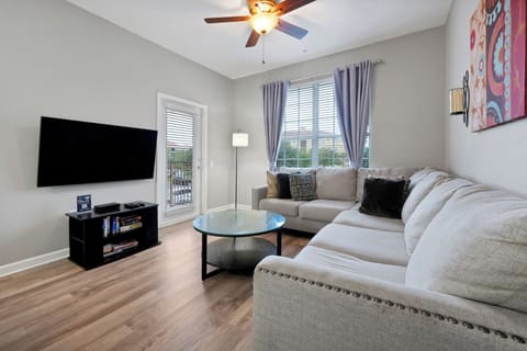 Relax in this bright, airy living room where plush sectional seating invites you to unwind after a day of exploring. Natural light pours through glass doors leading to your private outdoor space.