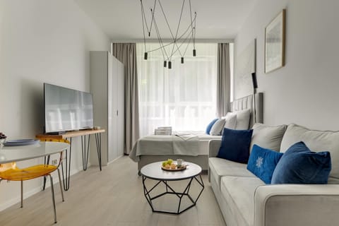 Przestrzeń apartamentu łączy funkcję sypialni, części wypoczynkowej i jadalnianej. Znajduje się w niej wygodne łóżko małżeńskie z hotelową pościelą i kompletem poduszek oraz rozkładana sofa zapewniająca dodatkowe miejsce do spania. 