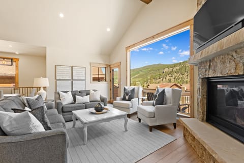 Relax in your inviting living room with vaulted ceilings, cozy fireplace, and stunning mountain views through expansive windows. Sink into plush seating after a day exploring the slopes.