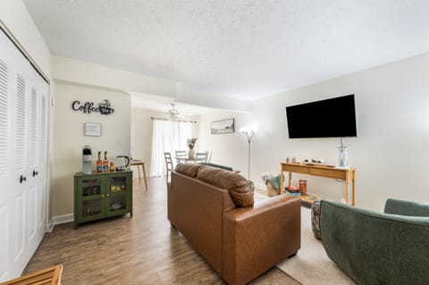 Bright inviting living room with Smart TV, coffee bar work desk & dining area.