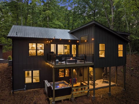 A bird's-eye view of the back decks with jacuzzi, lounge area, and fire table.