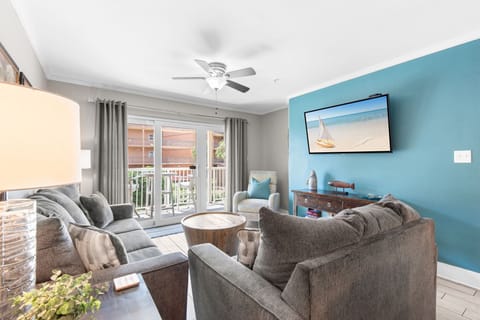 Unwind in your bright living room with plush seating, breezy ceiling fan, and coastal touches that set the tone for your beach getaway.