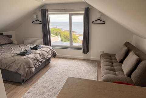 Wake to sweeping sea views from bed with a sofa to relax by the window