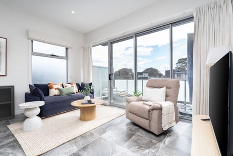 The bright open-plan living area is made for relaxing, with comfortable seating, plenty of natural light and expansive windows overlooking the surroundings.