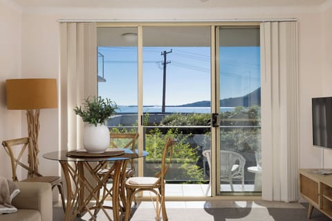 Sunny dining nook with balcony access and peaceful water views