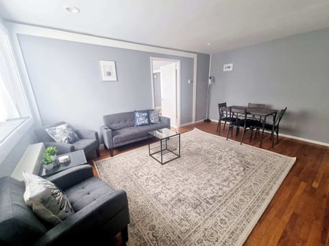 The living room comes furnished with essential pieces, including a comfortable sofa, a coffee table, TV stand, and dining table, providing immediate comfort upon move-in.
