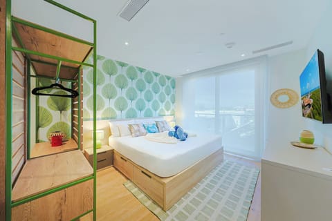 You'll love waking up in this bright, airy bedroom with cheerful green leaf wallpaper, soft lighting, and a modern ensuite visible through the stylish open shelving.