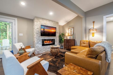 Settle into rich leather seating where your stone fireplace adds warmth and ambiance. Natural light streams through the windows, creating a welcoming retreat perfect for unwinding after your adventures.