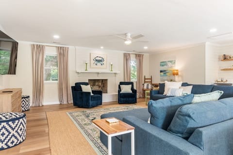 Walk in and let the color hit you: deep navy sofas, sun-drenched windows, and room for all fourteen of your favorite people.